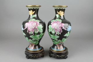 A pair of Japanese black ground cloisonne club shaped vases with floral decoration, raised on pierced wooden stands 10 1/2" 