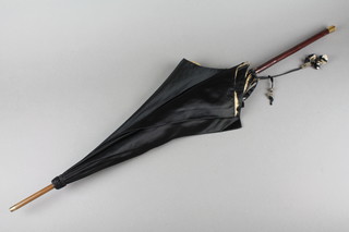 A Victorian parasol with black and white silk canopy and a gilt metal terminal