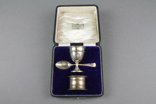 A cased silver christening set comprising egg cup, spoon and napkin ring, Birmingham 1949, 42 grams