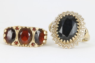A 9ct gold garnet set ring and a sapphire and diamond ditto, size P 1/2" and size P