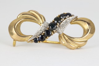 A 9ct gold sapphire and diamond open scroll brooch 