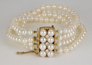 A 4 strand cultured pearl bracelet with a pearl and diamond set 9ct gold clasp