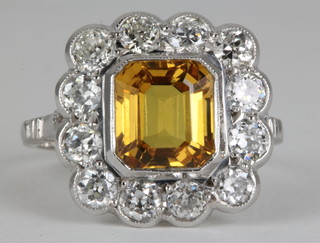 An 18ct white gold yellow sapphire and diamond ring, the centre rectangular cut stone approx 3.5ct surrounded by 12 brilliant cut diamonds. size 0 1/2