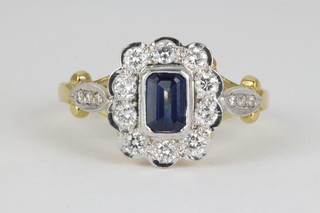 An 18ct yellow gold sapphire and diamond cluster ring, the centre emerald cut stone surrounded by 10 brilliants, size N 1/2 