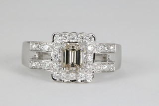 An 18ct white gold emerald cut diamond cluster ring with open shank, approx. 0.71ct surrounded by 28 brilliant cut stones, approx.0.41ct, size O 1/2