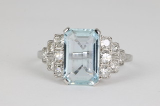 An 18ct white gold emerald cut aquamarine and diamond dress ring, the centre stone approx. 2.85ct flanked by 6 brilliant cut diamonds, approx. 0.5ct, size N