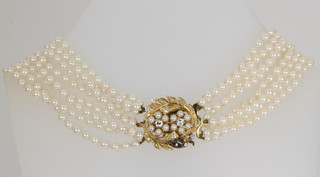 An 8 strand cultured pearl necklace with a diamond and pearl set gold floral clasp
