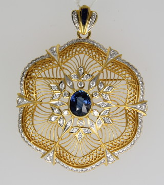 An 18ct gold sapphire and diamond open pendant brooch, the oval centre sapphire approx. 2ct surrounded by brilliant cut diamonds, gross weight 32 grams