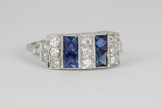 An 18ct white gold sapphire and diamond cocktail ring set with 15 brilliant cut diamonds and 4 princess cut sapphires, size O