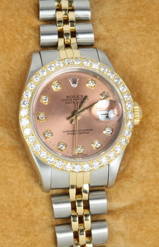 A lady's Rolex Oyster perpetual datejust wristwatch, with a bi-metallic strap and case, having a diamond set bezel and 5 minutes set dial, No.6917/6050496, in original box