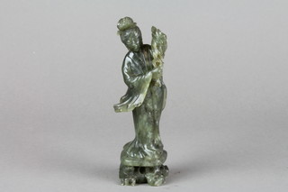 A nephrite carving of Guan Yin holding flowers on a raised base 6"