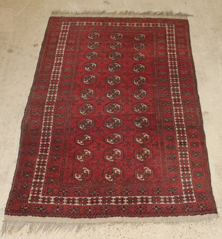 A red ground Afghan rug having 33 octagons to the centre 89" x 54" 