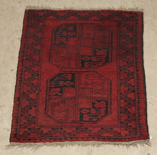 A red ground Afghan rug with 2 octagons to the centre 37" x 26" 