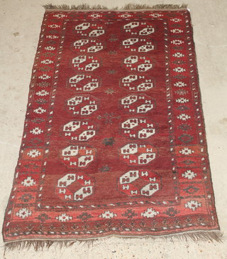 A red ground Afghan rug with 16 octagons to the centre 78" x 45" 