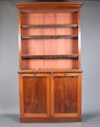 A Victorian mahogany bookcase on cabinet, the upper section with moulded cornice the interior fitted adjustable shelves, the base with shelved interior enclosed by arch panelled doors, raised on a platform base 83"h x 48"w x 15"d