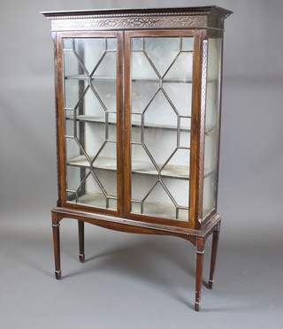 An Edwardian Chippendale style mahogany cabinet with moulded and dentil cornice, fitted shelves enclosed by an astragal glazed panelled door, raised on square tapering supports ending in spade feet 69 1/2"h x 43"w x 14 1/2"d