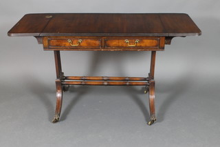 A mahogany sofa table fitted 2 drawers raised on standard end supports united by a turned stretcher 30"h x 36 1/2" when closed, 56" when open x 22"d 