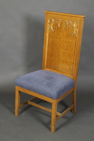 An ecclesiastical oak high back chair with upholstered seat raised on square supports with H framed stretcher