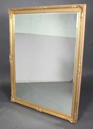 A rectangular bevelled plate wall mirror contained in a decorative gilt frame 54"h x 42"w 