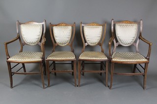 A pair of Edwardian inlaid mahogany shield back open arm chairs with upholstered seats together with a pair of shield back standard chairs raised on outswept supports (some inlay missing)