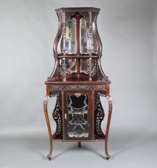 An Edwardian mahogany double corner cabinet, the upper section with bevelled plate mirrored back with columns and fret work decoration to the sides, the base fitted a cupboard enclosed by panelled doors and with niches, raised on cabriole supports 72"h x 31"w x 17"d