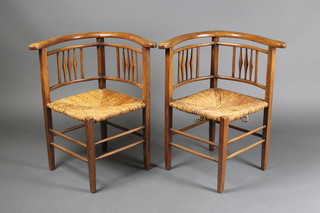 A pair of Arts & Crafts corner chairs with stick and rail backs and woven cane seats
