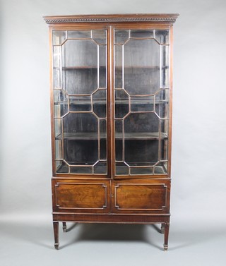 A Chippendale style mahogany display cabinet with moulded and dentil cornice, enclosed by astragal glazed panelled doors, the base fitted a cupboard, 76 1/2"h x  41 1/2"w x 15 1/2"d 