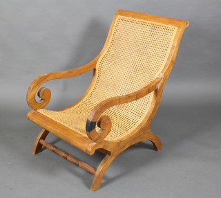 A teak planters style open arm chair with woven cane back, raised on scroll supports (arm f and r) 