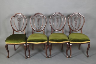 A set of 4 Edwardian mahogany shield back dining chairs with pierced splat backs, the seats of serpentine outline, raised on cabriole supports