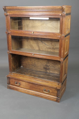 A Victorian carved oak 3 section Globe Wernicke style bookcase with moulded and dentil cornice and fluted columns to the side, the base fitted 1 long drawer with brass swan neck drop handles 50 1/2"h x 35"w x 15"d 