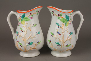 A pair of Victorian polychrome jugs decorated with a bird among trees 9" 