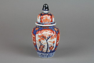 A 19th Century Imari baluster vase and cover decorated with panels of flowers and trees 6" 