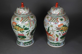 A pair of contemporary Chinese baluster vases and covers with shi shi finials and panels of fish 22" 