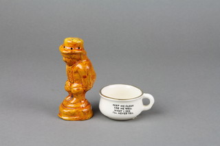 A 19th Century treacle glazed pepperette in the form of a crouching gentleman with lowered trousers 4", a novelty miniature chamber pot 