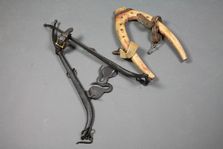 An iron and wooden horse head collar 12" and a pair of iron horse hanes