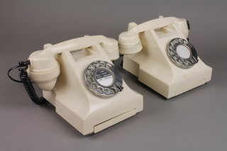 A pair of white Bakelite dial telephones 