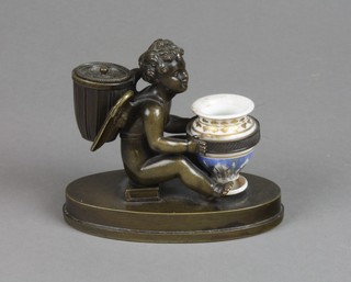 A Regency bronze and porcelain inkwell sander in the form of a seated cherub grasping a shaped urn and with sander panier to his back, raised on an oval base 3"