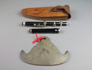 A curious shaped bronze gong 9 1/2" together with a pipe by Boosey & Hawkes contained in a leather military case