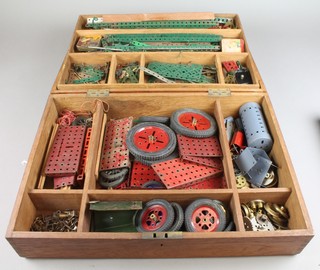 A wooden box containing a collection of green and red Meccano together with a Meccano accessory kit 