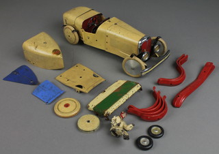 A Meccano clockwork model racing car including 2 running boards, radiator, 3 pairs of mud guards, a metal figure of a driver (hand and foot f)