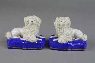 A pair of Victorian style Staffordshire reclining dogs and puppies on raised blue and gilt bases 3 1/2" 