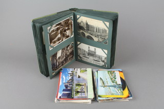 A green album of postcards and a collection of loose postcards