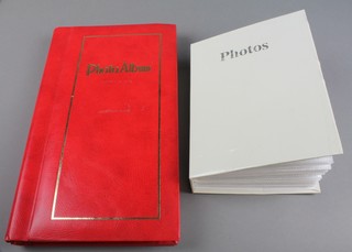 A red album of various coloured and other postcards together with a white album of coloured postcards and birthday cards 