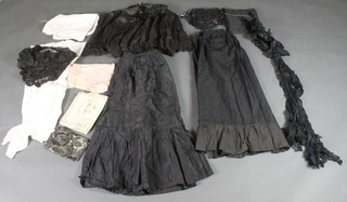 A lady's Victorian black embroidered cape and bonnet, 2 black skirts and various fabrics, contained in a wicker laundry box 