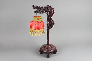 A Chinese carved hardwood table lamp in the form of a dragon 19"h