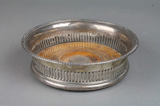 A George III silver coaster with demi-fluted decoration and armorial crest