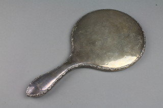 A silver backed circular hand mirror