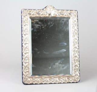 A repousse silver easel frame mirror with bevelled plate enclosed by stylised flowers and vacant cartouche London 1988 14 1/2" x 10 1/2" 