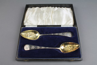 A cased pair of George III silver gilt berry spoons with typical decoration, London 1820, 144 grams  
