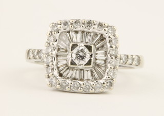 An 18ct white gold diamond cluster ring set with tapered baguettes and brilliant cut stones, size L 1/2